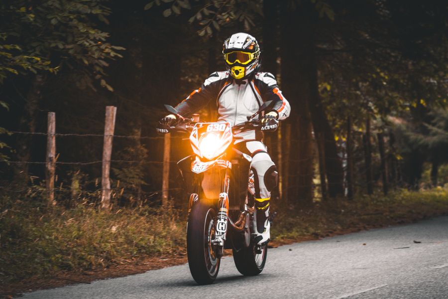 Motociclista con equipo completo en carretera rural
