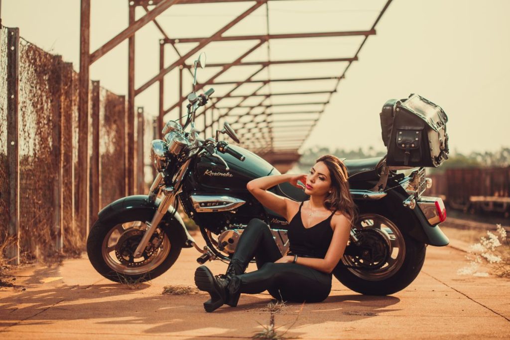 mujer junto moto estacionada Mujer junto a moto estacionada